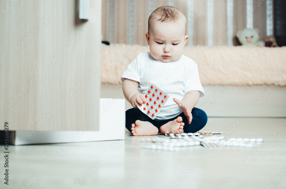 baby, girl sitting on the floor in the hands of pills baby, girl sitting on the floor in the hands of pills