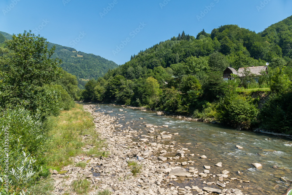 the rapid flow of a mountain river carries stones from the summits near the village