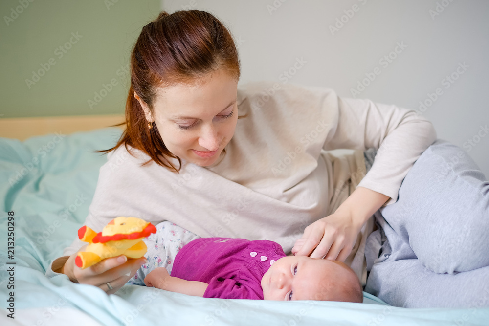 Newborn baby playing with mother