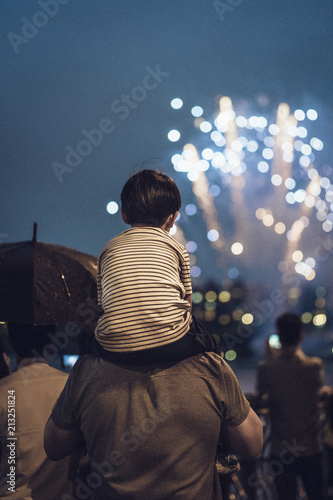 Father and son watching a fireworks festival.