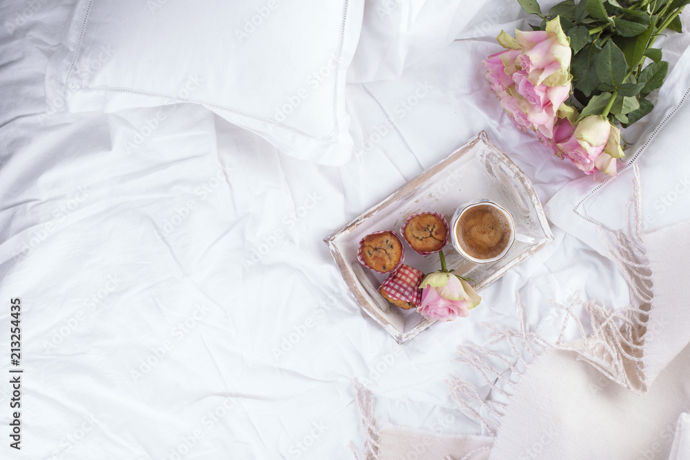 Coffee and bouquet of pink roses in bed, romance and coziness. Good morning. Breakfast in bed. Copy space. Coffee and bouquet of pink roses in bed, romance and coziness. Good morning. Breakfast in bed. Copy space.