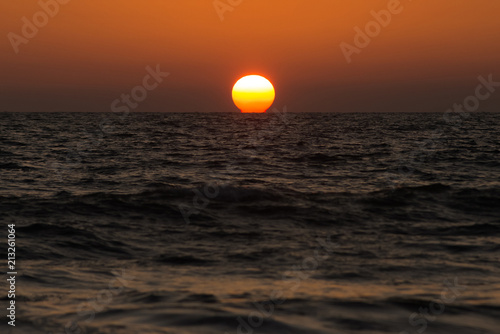 Fototapeta Naklejka Na Ścianę i Meble -  The great red of sunset the sun sinks in the sea