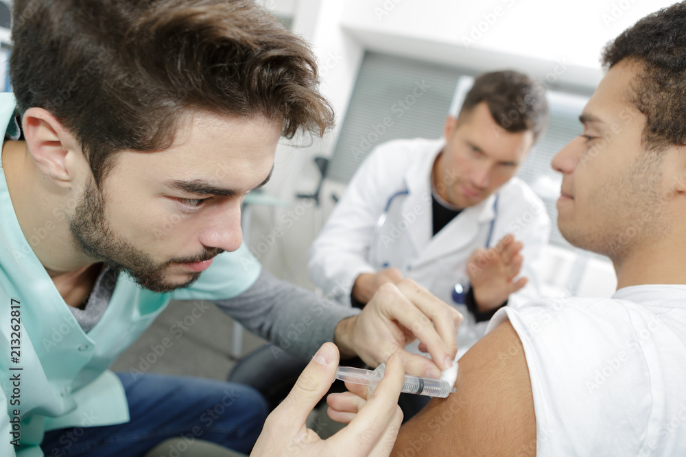 Obraz premium male nurse doing injured man tetanus toxoid injection