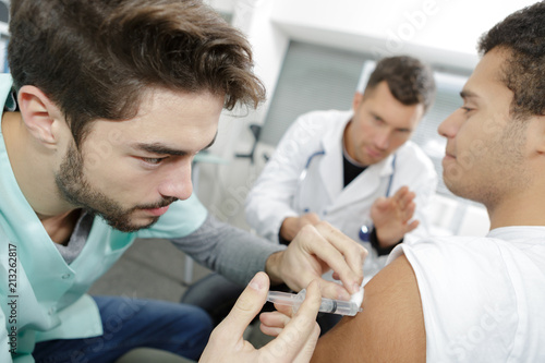 male nurse doing injured man tetanus toxoid injection
