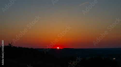 Cloudless sky during sunset. The sun is on the horizon line.. © olgapkurguzova