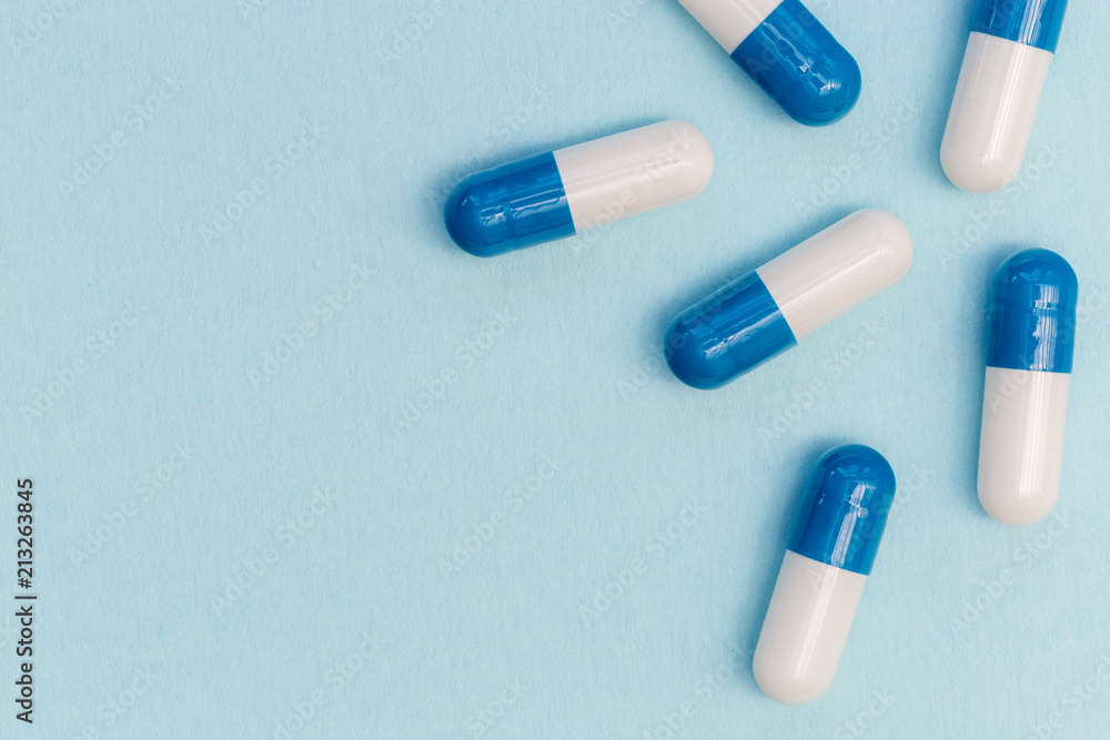 Drugs pills capsules on blue background abstract concept Drugs pills capsules on blue background abstract concept