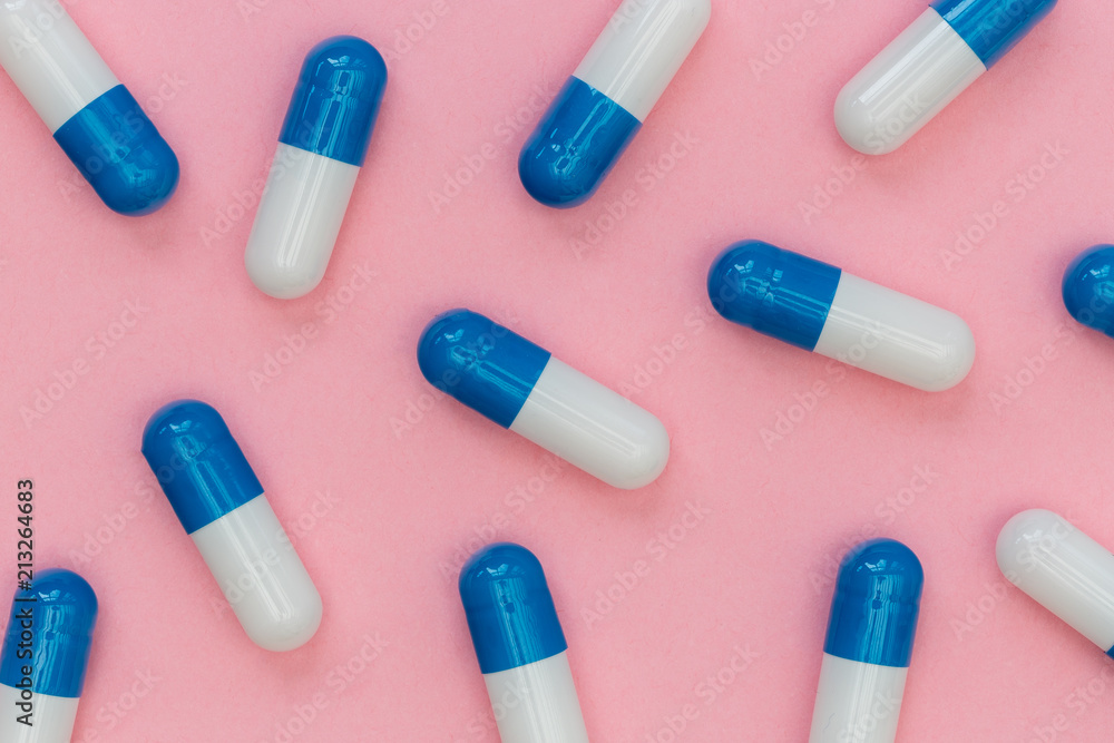 Drugs pills capsules on pink background abstract concept Drugs pills capsules on pink background abstract concept
