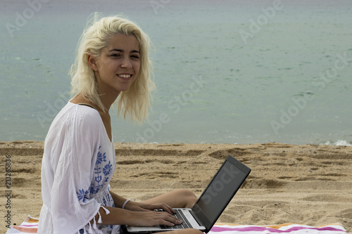 Relaxed woman typing on a laptop on the beach photo