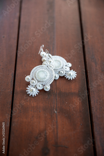 White wedding earrings abalone on wooden background photo