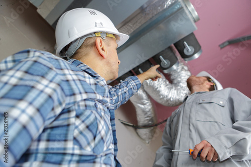 Billede på lærred men setting up ventilation system indoors