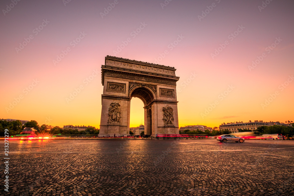 Arch of triumph at twilight. Arc de Triomphe at end of Champs Elysees in Place Charles de Gaulle with cars and trails of lights. Popular landmark and tourist attraction in Paris capital of France.