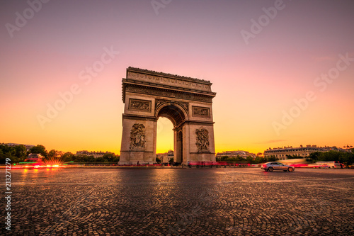 Arch of triumph at twilight. Arc de Triomphe at end of Champs Elysees in Place Charles de Gaulle with cars and trails of lights. Popular landmark and tourist attraction in Paris capital of France. photo