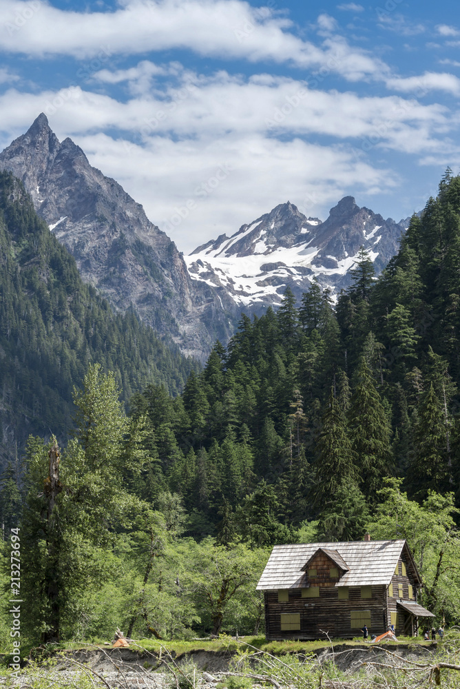 Abandoned mountain cabin chalet cottage in pristine wilderness in Washington vertical portrait.