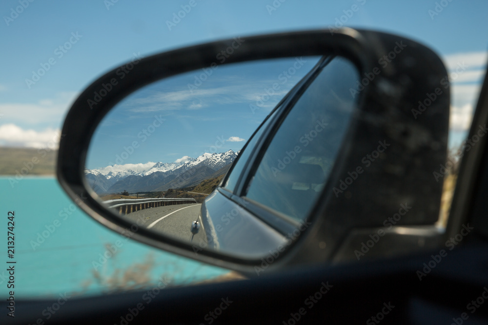Looking back at Aoraki Mount Cook national park, south island, New Zealand. from a car rear view wing mirror