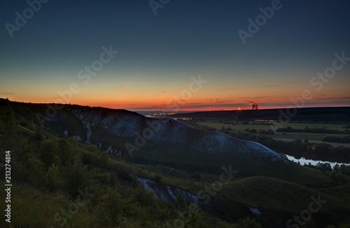 Stars of outer space in the night sky over the river valley. Landscape in the twilight on long exposure.