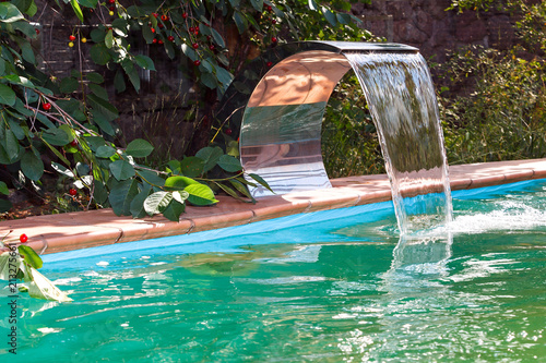 Water supply to the pool by a waterfall. Recirculation and cleaning system.