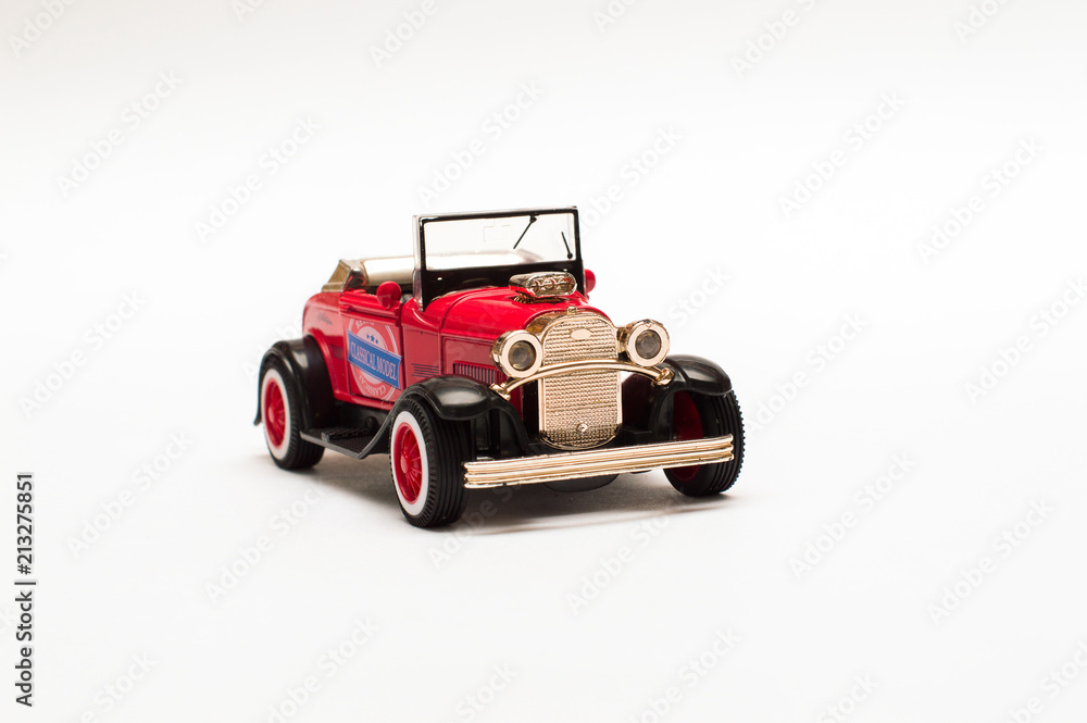 Red retro car, toy model on white background 