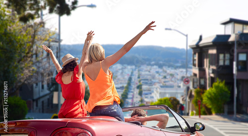 Photography leisure, road trip, travel and people concept - happy friends driving in convert