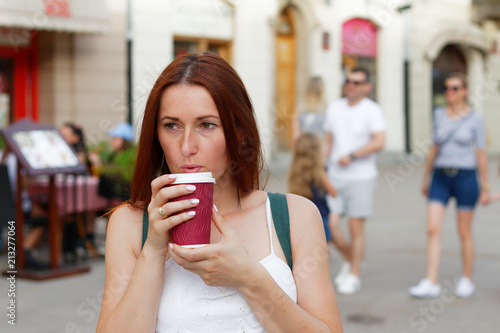 Young beutiful woman blowing on cup of hot coffee