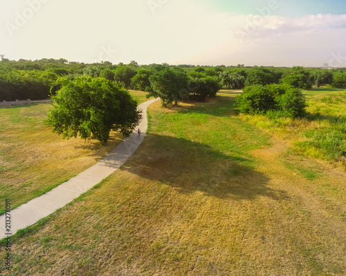 Top view park paved pathway with biker riding bike in Irving, Texas, USA. Aerial view path for walking, running, biking, rollerblading photo