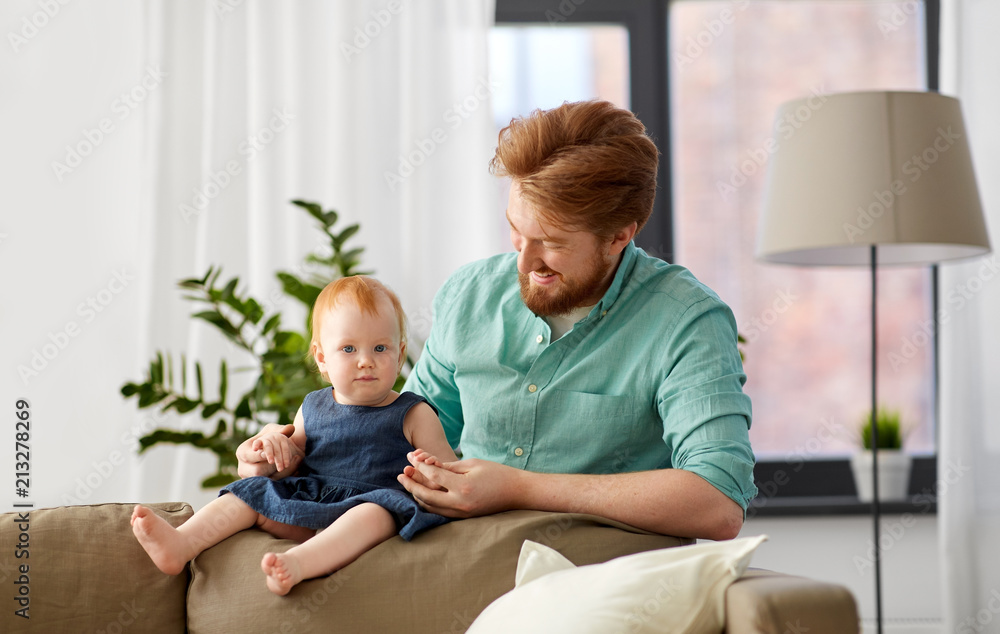 Fototapeta premium family, fatherhood and people concept - happy red haired father with little baby daughter at home