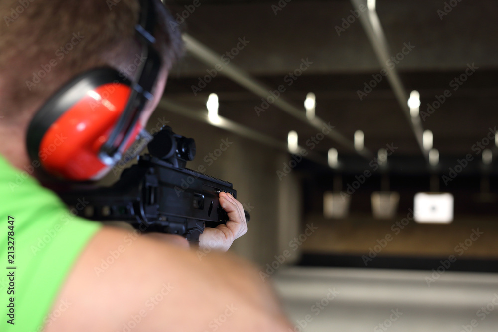 Obraz premium Strzelectwo. Przystojny mężczyzna trenuje strzelanie na strzelnicy sportowej.