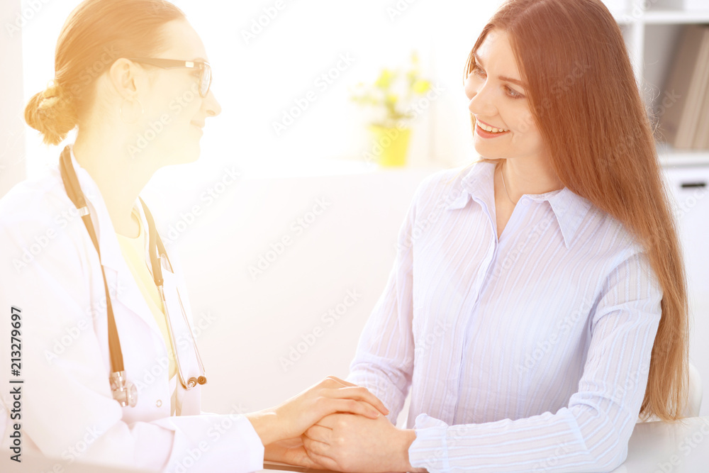 Doctor and patient sitting at the desk near window Doctor and patient sitting at the desk near window