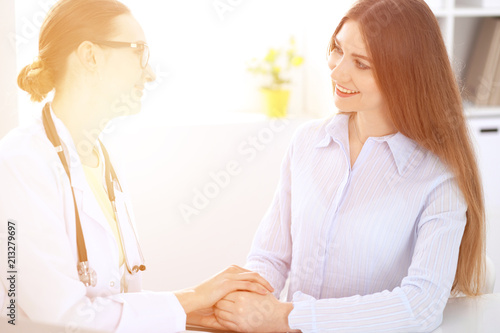 Doctor and  patient  sitting at the desk near window