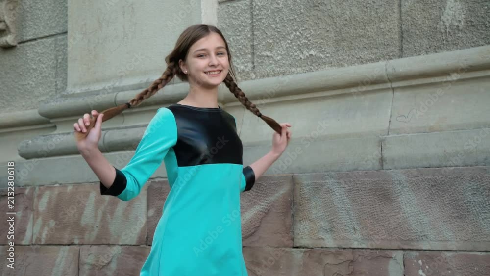Carefree young girl poses with smile at building outdoors. 4K Carefree young girl poses with smile at building outdoors. 4K