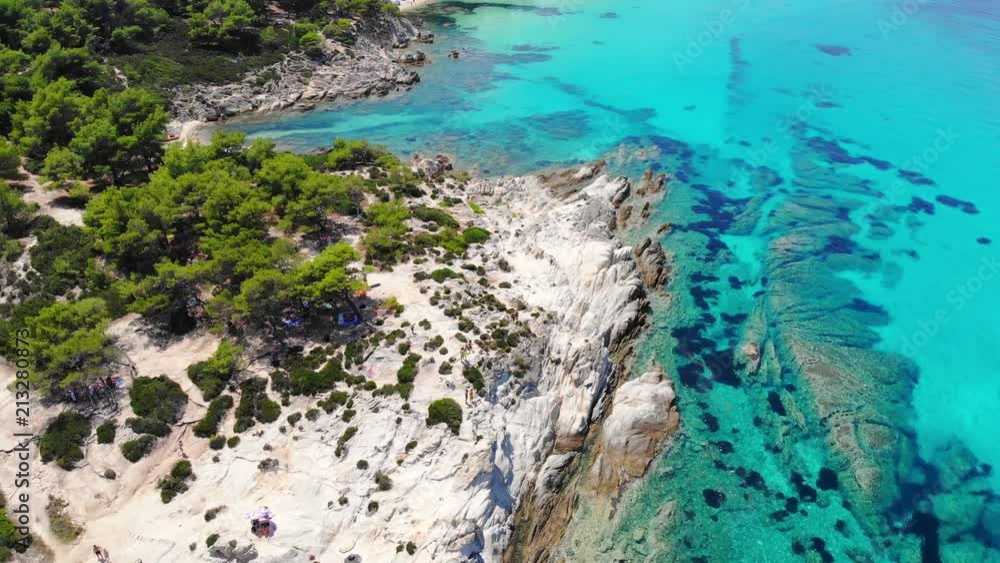 Aerial view of beautiful sandy and rocky Orange beach, people sunbathing and swimming. Drone shot flying over amazing famous Orange also called Portokali beach on Sithonia near Sarti, Greece Aerial view of beautiful sandy and rocky Orange beach, people sunbathing and swimming. Drone shot flying over amazing famous Orange also called Portokali beach on Sithonia near Sarti, Greece