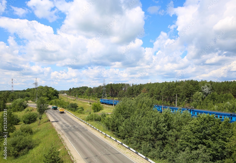Panorama with passenger train and cars.