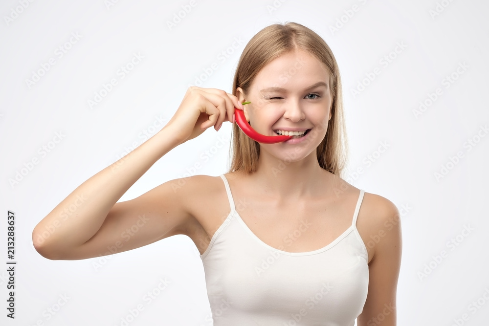 Female mouth holding red hot chili pepper. Female mouth holding red hot chili pepper.
