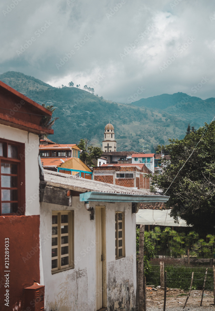 Church tower in the main plaza of Salento visible over the roofs of houses in the small town in the coffee region of Colombia