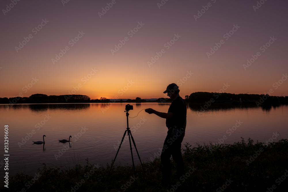 Silhouette von einem Fotografen und Schwan beim Sonnenuntergang am Rhein  Iffezheim