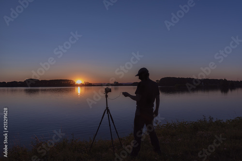 Silhouette von einem Fotografen beim untergang der Sonne am Rhein Iffezheim