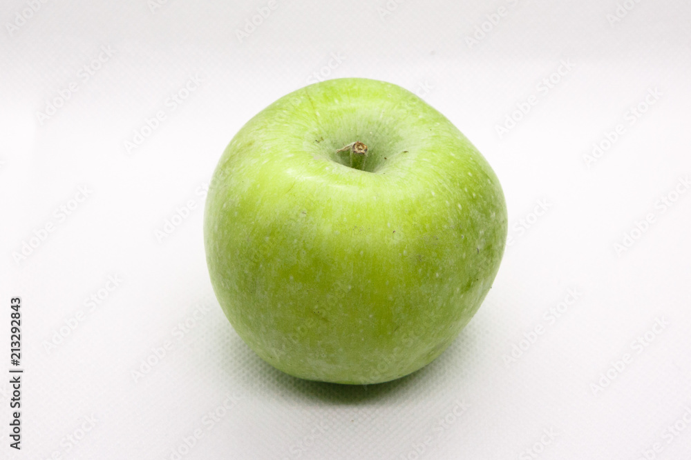 Green apple is lying on a white background Green apple is lying on a white background