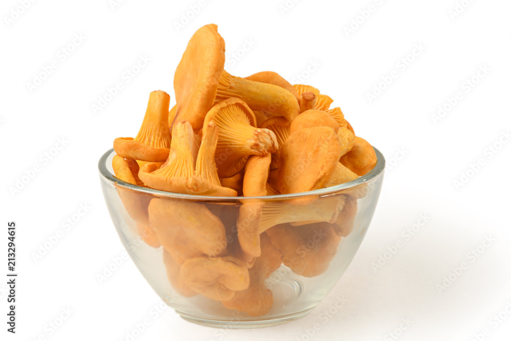 Chanterelle mushrooms lie in transparent glass bowl isolated on white background side view closeup Chanterelle mushrooms lie in transparent glass bowl isolated on white background side view closeup