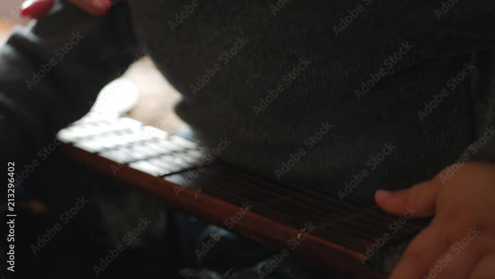 A little boy playing with a guitar at home. A little boy playing with a guitar at home.