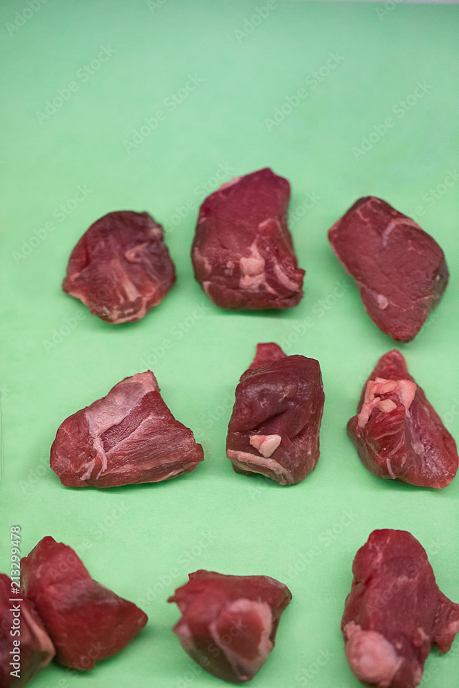 Obraz premium Raw beef tips on green background