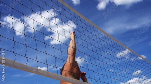 Man spiking a beach volleyball slow motion close up
