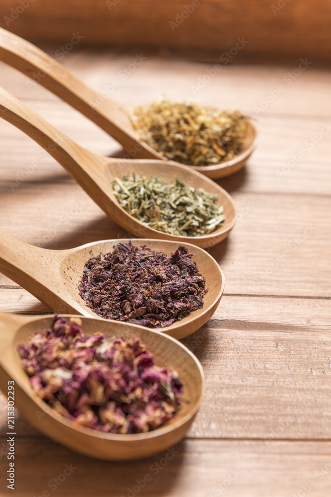 Wooden spoons with different herbs for infusion. Wooden spoons with different herbs for infusion.