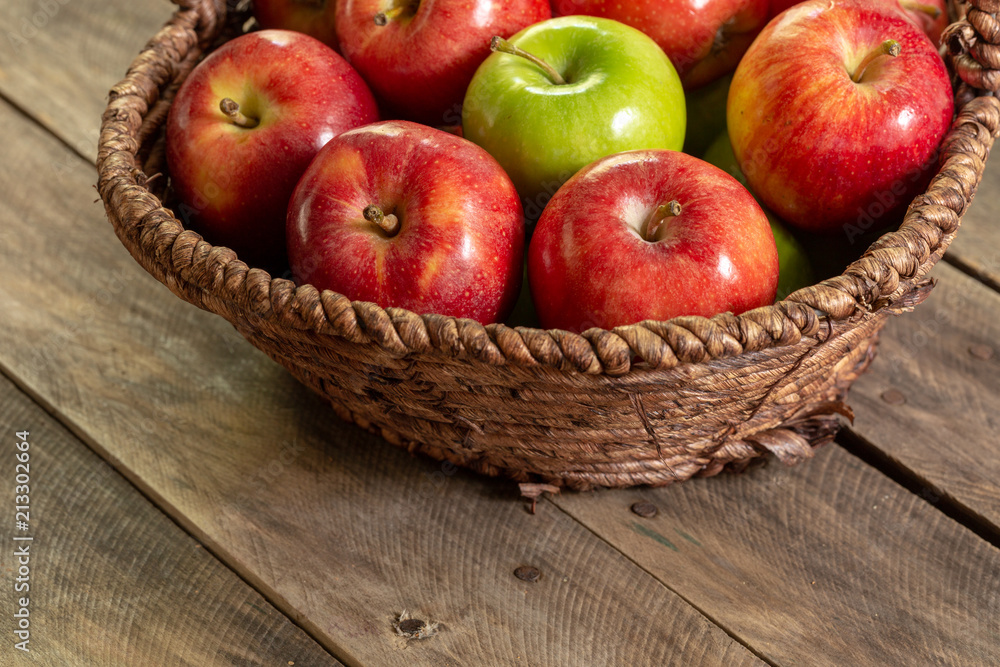 Apples red and green on rustic wooden table in basket 