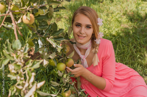 A girl is picking apples in the garden