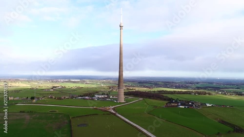 Aerial view of historic Emley Moor Transmitting station in English countryside, drone orbiting mast photo