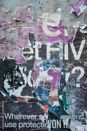 The tattered remains of a wall of posters with HIV ? visible