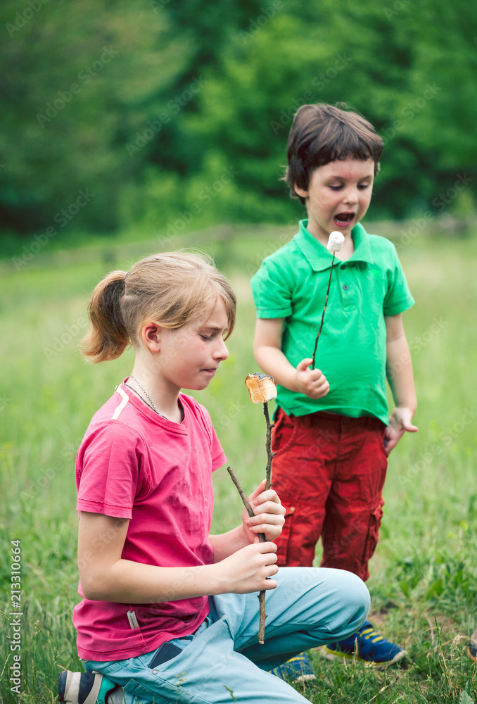 Fototapeta premium The boys eat fried marshmallows.