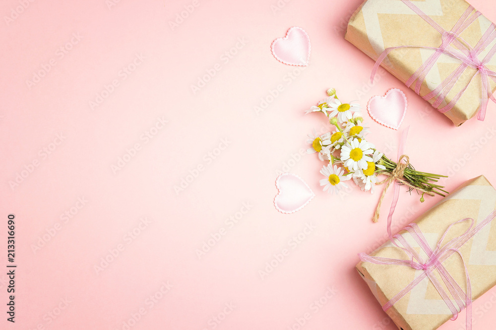 Little bunch of chamomiles with gift boxes on a pink background. Copy space. Little bunch of chamomiles with gift boxes on a pink background. Copy space.
