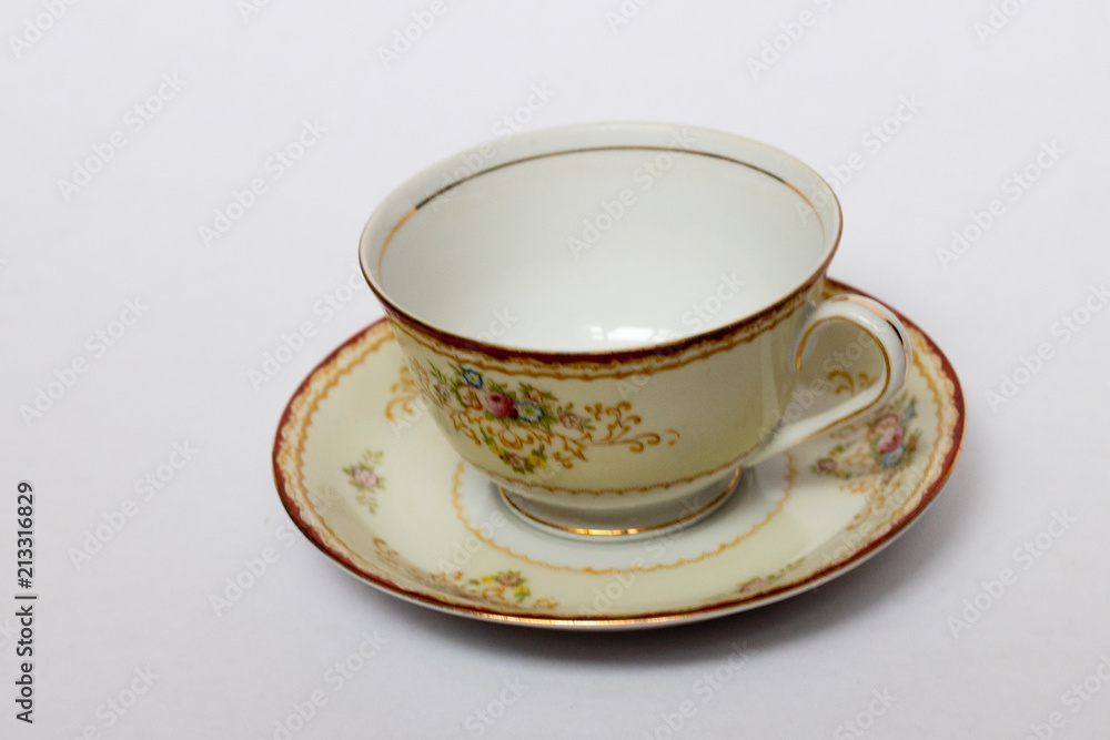 An isolated porcelain cup in a saucer An isolated porcelain cup in a saucer