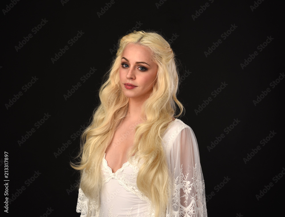 close up portrait of a blonde girl wearing white lace gown.  black studio background.