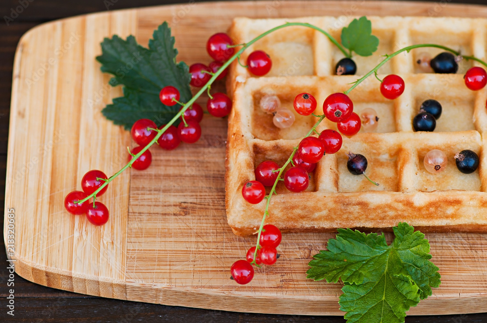 Wafers decorated with red currants on a wooden background, natural product, food - dessert, pastry with fruit.